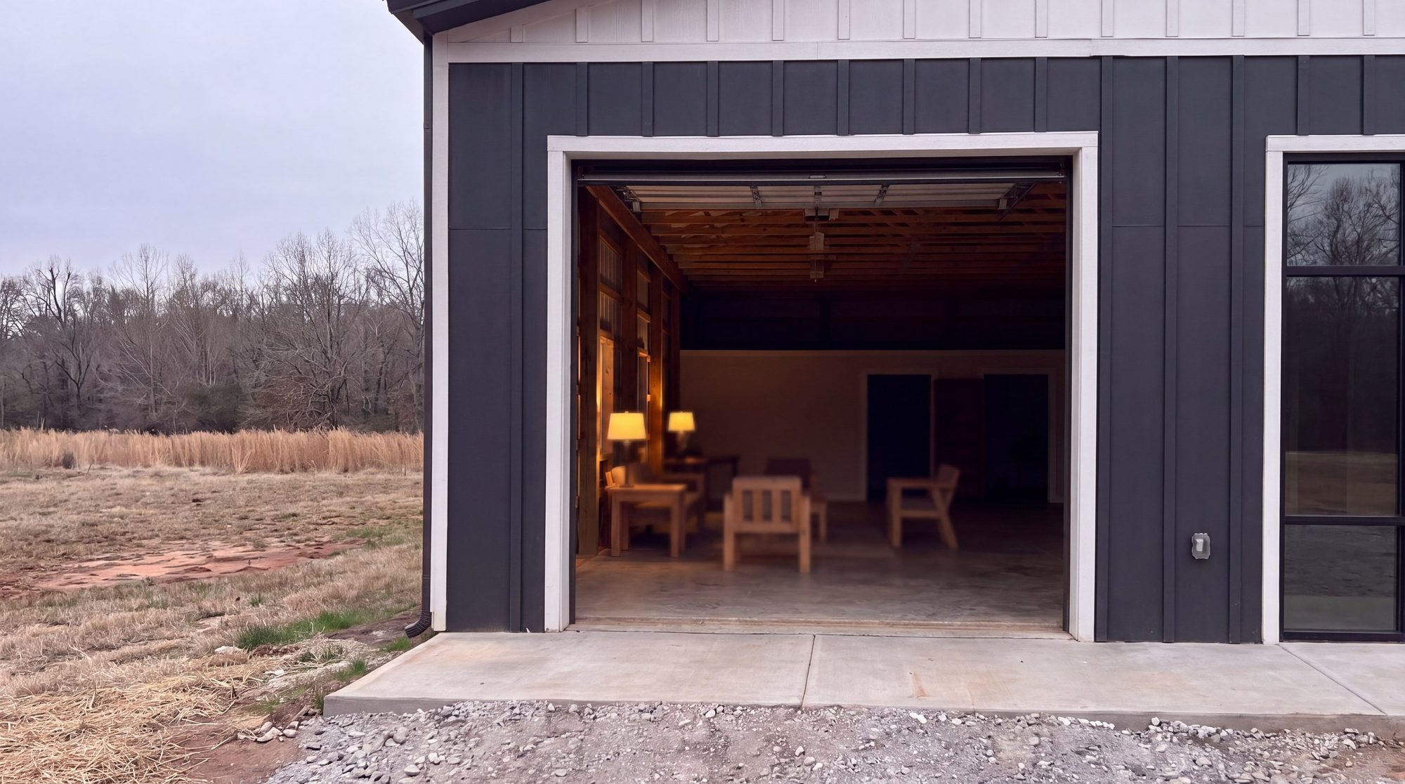 The big door open from outside, lamps lit within